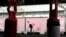 FILE - A passer-by walks past pedestrian traffic pylons in an outdoor mall where most stores remain closed out of concern for the coronavirus, in Dedham, Mass., April 22, 2020.