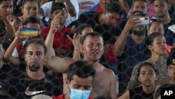 El migrante venezolano Eymar Hernández, centro, asiste a una asamblea mientras se refugia en un complejo deportivo en Huixtla, estado de Chiapas, México, el miércoles 8 de junio de 2022. (AP Foto/Marco Ugarte)