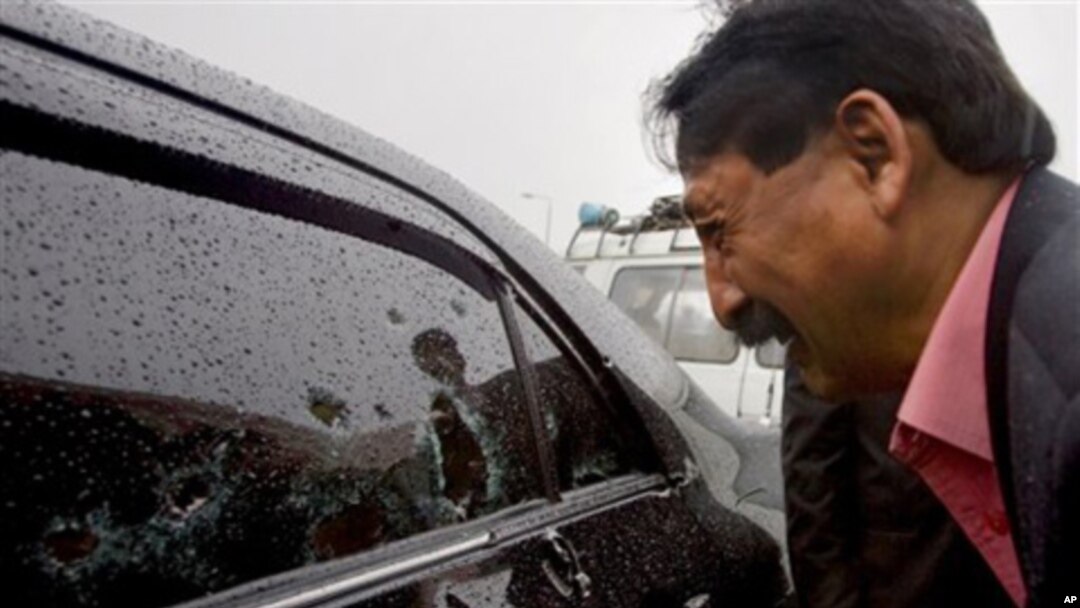 Wasif Ali Khan, a friend of Pakistan's government minister for religious minorities Shahbaz Bhatti looks at the bullet-riddled window of car while he mourns over his death, Islamabad, Pakistan, March 2, 2011.