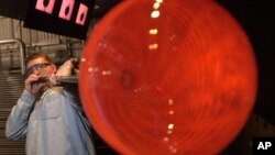 Seorang artis seni tiup kaca sedang membuat vas besar dalam sebuah demo di Museum Gelas di Corning, New York. (Foto:Dok) 