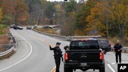 Agentes de policía hablan con un automovilista en un control de carretera, el jueves 26 de octubre de 2023, en Lisbon, Maine, en búsqueda del sospechoso de los tiroteos masivos del miércoles. El tiroteo tuvo lugar en un restaurante y una bolera en la cercana Lewiston, Maine.