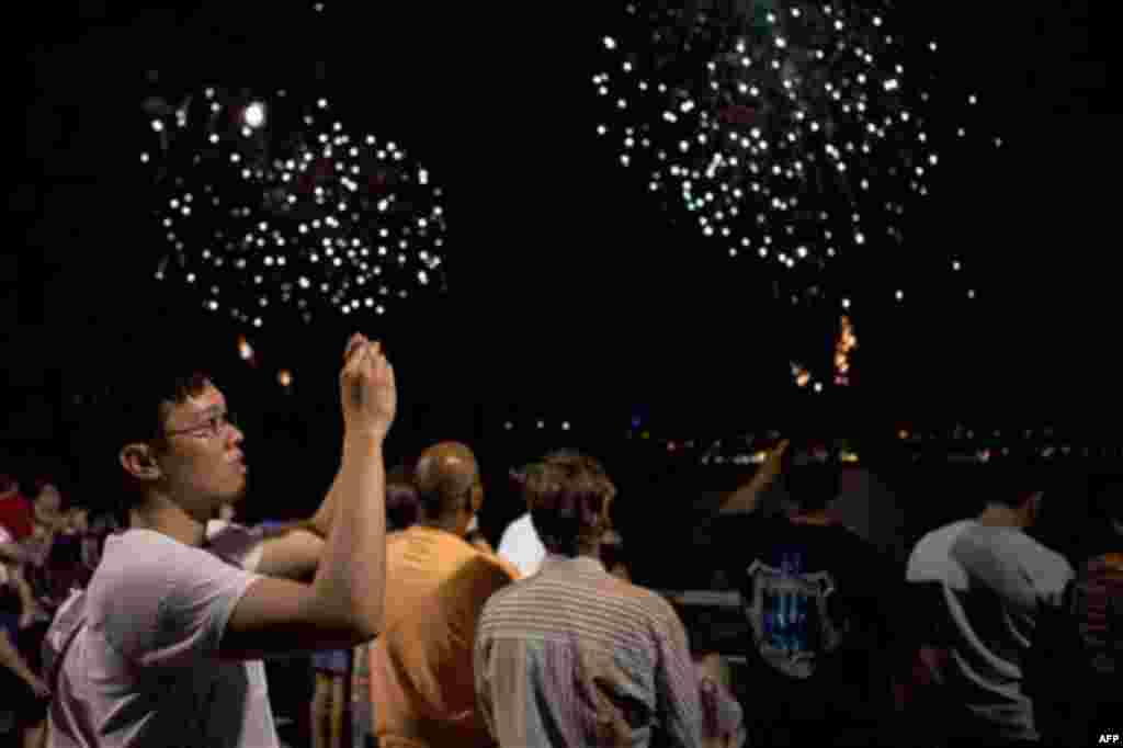 Spectators watch the annual Independence Day fireworks over the Hudson River, Monday, July 4, 2011, in New York. A portion Manhattan's west side is closed to vehicular traffic, allowing pedestrians to camp out and wait for the 40,000 shells launched after