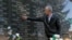 FILE - A survivor of the Cuska massacre points out the names of family members as he visits a cemetery in the village of Cuska, Kosovo, on Feb. 11, 2014.