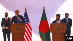 Utusan iklim AS John Kerry (dua dari kiri) dan Menteri Luar Negeri Bangladesh AK Abdul Momen (dua dari kanan) menyaksikan konferensi pers di Dhaka, 9 April 2021. (Foto: Rehman Asad / AFP)