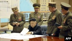 Pemimpin Korea Utara, Kim Jong-un tengah mendiskusikan rencana penyerangan dengan para pejabat tinggi angkatan bersenjata Korut dalam rapat darurat, 29 Maret 2013. (AFP Photo/KCNA VIA KNS). 