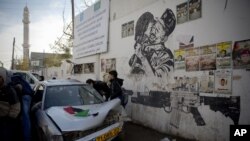 Palestiniens examinant le véhicule utilisé dans une tentative d'attaque contre des soldats israéliens, faubourg de Ramallah, Cisjordanie, le 16 décembre 2015. (AP Photo/Majdi Mohammed) 