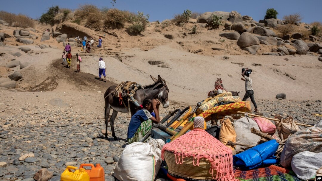 FILE - Refugees who fled the conflict in Ethiopia's Tigray region arrive with their furniture and donkey on the banks of the Tekeze River on the Sudan-Ethiopia border, in Hamdayet, eastern Sudan, Nov. 21, 2020. 