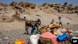 FILE - Refugees who fled the conflict in Ethiopia's Tigray region arrive with their furniture and donkey on the banks of the Tekeze River on the Sudan-Ethiopia border, in Hamdayet, eastern Sudan, Nov. 21, 2020. 