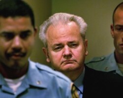 FILE - Slobodan Milosevic, center, enters the courtroom to appear before the court of the International Criminal Tribunal for the former Yugoslavia in The Hague, the Netherlands, Dec. 11, 2001.