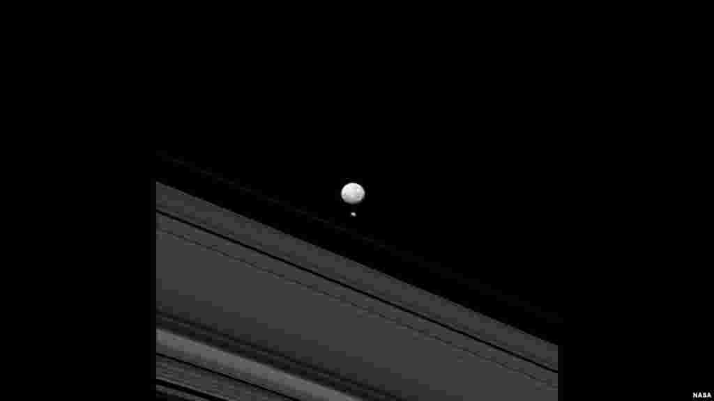 Dua bulan planet Saturnus - Mimas dan Pandora - muncul bersamaan dalam gambar yang diambil oleh pesawat antariksa NASA, Cassini. Ukuran kecil bulan Pandora berarti bahwa ia tidak memiliki gravitasi yang cukup besar untuk menarik dirinya menjadi bentuk bulat seperti &quot;saudaranya&quot; yang berukuran lebih besar, bulan Mimas (foto: NASA).