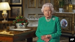 In this image taken from video and made available by Buckingham Palace, Britain's Queen Elizabeth II addresses the nation and the Commonwealth from Windsor Castle, Windsor, England, Sunday April 5, 2020. 
