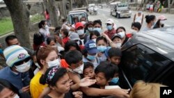 Residents scramble to obtain relief supplies being distributed at a town near Taal volcano, in Tagaytay, Cavite province, Philippines, Jan.19, 2020.