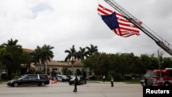 A hearse carrying the casket of Aaron Feis, one of the victims of the mass shooting at Marjory Stoneman Douglas High School, drives past a U.S. flag, placed on a fire truck, during his funeral service in Coral Springs, Florida, U.S., Feb. 22, 2018. 