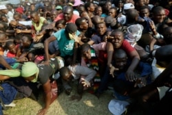 Mourners stampede after the arrival of the coffin carrying former President Robert Mugabe at the Rufaro Stadium in Harare, Sept. 12, 2019.