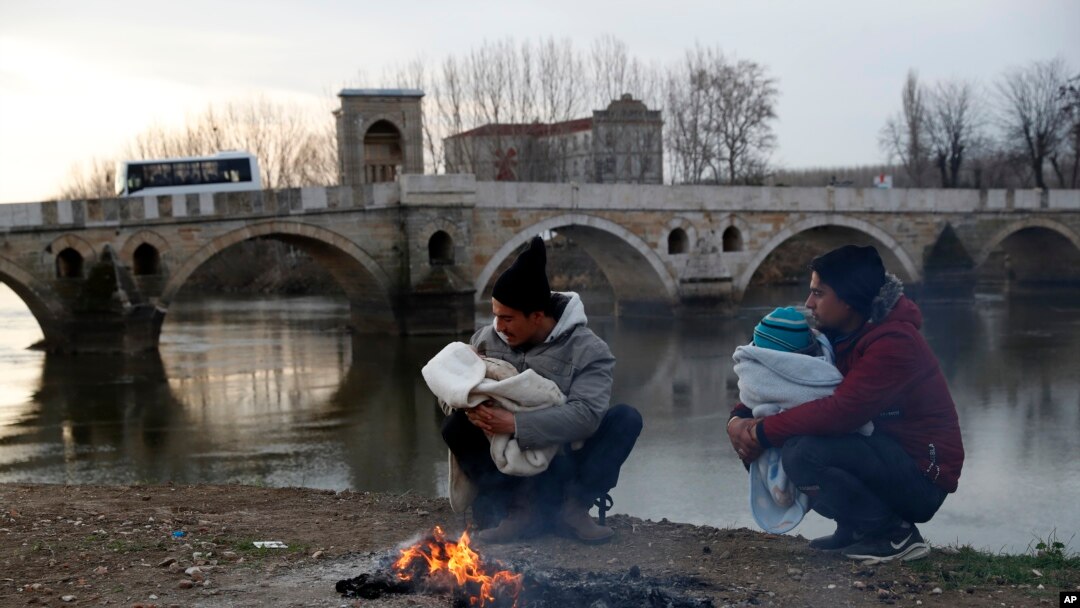 Migranti drže svoje bebe u pokušaju da se zagreju u blizini reke u Jedrenu, Turska, u blizini tursko-grčke granice, 4. marta 2020.