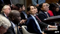 (FILES) In this file photo taken on December 11, 2019 Myanmar's State Counsellor Aung San Suu Kyi (C) stands before the UN's International Court of Justice in the Peace Palace of The Hague, on the second day of her hearing on the Rohingya genocide case.