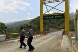 FILE - Myanmar police survey a bridge in Myanmar's Chin state, near the border with India where huge quantities of Indian-made pseudoephedrine, the main ingredient for methamphetamine is smuggled into Myanmar, May 10, 2016.