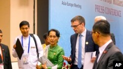 FILE - Aung San Suu Kyi talks with Estonia Foreign Minister and a representative of EU Sven Mikser, second right, as they leave a press conference after the Asia Europe Foreign Ministers (ASEM) at Myanmar International Convention Centre (MICC), Nov. 21, 