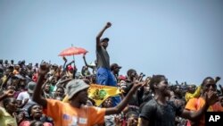 People in the stands sings songs as members of the public queue up to view the body of former president Robert Mugabe, at the Rufaro stadium in the capital Harare, Zimbabwe Friday, Sept. 13, 2019. The ongoing uncertainty of the burial of Mugabe, who…