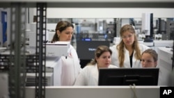 FILE - Lab technicians work at the Brazilian Doping Control Laboratory (LBCD) before a visit by Brazil's sports minister in Rio de Janeiro, Brazil, Friday, May 8, 2015.