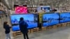 FILE - Young shoppers look over a row of large-screen televisions on display in a Costco warehouse Dec. 19, 2024, in Denver. 