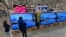 FILE - Young shoppers look over a row of large-screen televisions on display in a Costco warehouse Dec. 19, 2024, in Denver. 