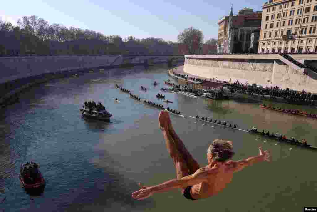 Marco Fois dives into the Tiber River from the Cavour bridge, as part of traditional New Year celebrations, in Rome, Italy.