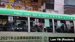 Sebuah bus dengan poster para caleg dalam pemilihan legislatif di Hong Kong, China, 15 Desember 2021. (Foto: Lam Yik/Reuters) 