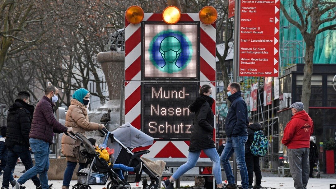 An electronic board reminds people to wear the mandatory face masks in a shopping street in Dortmund, Germany, Monday, Nov. 23, 2020.