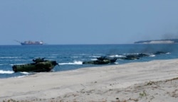 FILE - Amphibious Assault Vehicles carrying U.S. and Philippine troops, make a beach landing during the Joint US-Philippine Military Exercise dubbed "Balikatan 2019," April 11, 2019, off San Antonio, Zambales province northwest of Manila.