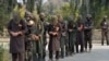 FILE - Forces with Afghanistan's National Directorate Security (NDS) escort alleged Taliban fighters after they are presented to the media, in Jalalabad, Afghanistan, Jan. 23, 2019.