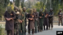 FILE - Forces with Afghanistan's National Directorate Security (NDS) escort alleged Taliban fighters after they are presented to the media, in Jalalabad, Afghanistan, Jan. 23, 2019.