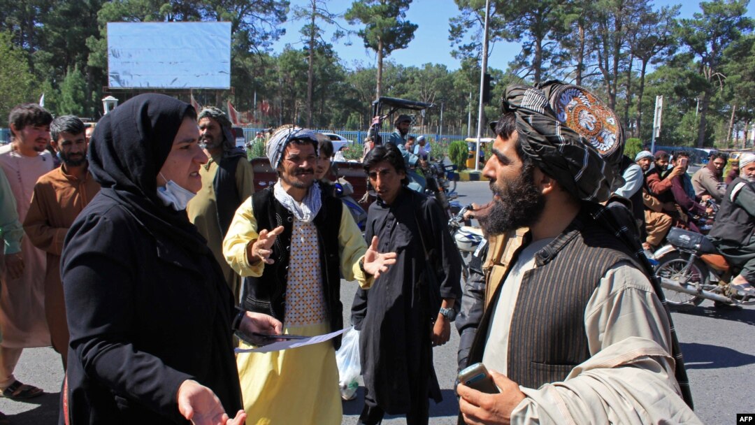 خۆپیشاندەرێکی ئەفغانی ژن لەگەڵ ئەندامێکی تاڵیباندا لە مشتومڕدایە، 2 ی 9 ی ساڵی 2021