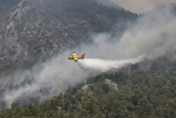 A firefighting plane from Spain drops water to a wildfire near Koycegiz, Turkey, Aug. 4, 2021.