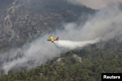 A firefighting plane from Spain drops water to a wildfire near Koycegiz, Turkey, Aug. 4, 2021.