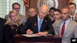 El gobernador de Florida, Rick Scott, firma la Ley de Seguridad Pública Marjory Stoneman Douglas que impone mayores controles a las ventas de armas en ese Estado.