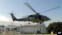US Navy helicopter lands next to US troops in front of heavily damaged presidential palace in Port-au-Prince 19 Jan 2010