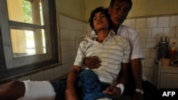 An injured Rakhine Buddhist man leans on his father at a hospital in Sittwe, the capital of Myanmar's western Rakhine state after they were recently injured at the four different districts outside Sittwe, October 26, 2012.