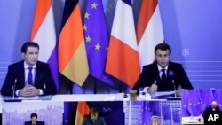 French President Emmanuel Macron, right, and Austria's Chancellor Sebastian Kurz, left, speak via videoconference shown on a screen in the European Council building in Brussels, Belgium, Nov. 10, 2020.