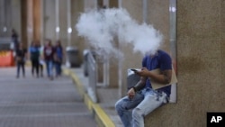 A Filipino uses an electronic cigarette outside a mall in Manila, Oct. 11, 2016.