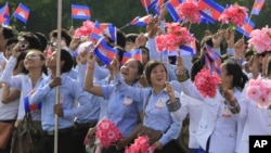 Cambodian students wave their national flags during a ceremony to celebrate the country's 60th Independence Day.