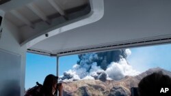 FILE - In this Dec. 9, 2019, file photo provided by Michael Schade, tourists on a boat look at the eruption of the volcano on White Island, New Zealand.