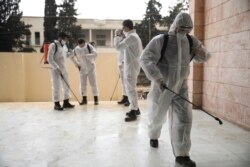 Members of a humanitarian aid agency disinfect Ibn Sina hospital as prevention against coronavirus in the city of Idlib, Syria, Thursday, March 19, 2020. (AP Photo/Ghaith Alsayed)