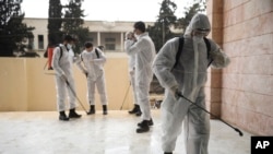 Members of a humanitarian aid agency disinfect Ibn Sina hospital as prevention against coronavirus in the city of Idlib, Syria, Thursday, March 19, 2020. (AP Photo/Ghaith Alsayed)
