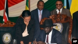 Le président Salva Kiir du Soudan du Sud signe l'accord de paix avec à l'arrière-plan à gauche le président du Kenya Uhuru Kenyatta et à droite le Premier ministre éthiopien Hailemariam Desalegn mercredi 27 aout 2015 à Juba, Soudan du Sud.