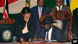 President Sudan Selatan Salva Kiir (duduk) menandatangani perjanjian damai dengan pemberontak di ibukota Juba, hari Rabu (26/8).