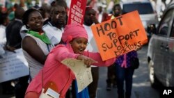 FILE - Doctors and other medical staff protest the detention of their union leaders, outside an appeals court in Nairobi, Kenya, Feb. 15, 2017. A court released seven doctors who were officials in the medics union; they had been jailed earlier in the week for not calling off a strike by doctors working in public institutions.