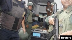 Militares venezolanos evacuan a heridos durante la requisa en el centro penitenciaría de Uribana.