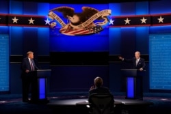 FILE - President Donald Trump and Democratic presidential candidate former Vice President Joe Biden speaking during the first presidential debate with moderator Chris Wallace of Fox News, center, Sept. 29, 2020, in Cleveland, Ohio.