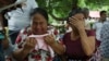 Mujeres lloran mientras explican que tres de sus familiares fueron asesinados el día anterior en El Ripial, estado de Apure, Venezuela, luego de cruzar el río hacia Arauquita, Colombia, el viernes 26 de marzo de 2021. Los venezolanos buscan refugio en Col